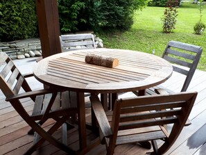 A wooden deck with a round table and four chairs. - Beautiful duplex with garden in Chamonix, 4 people, pets allowed, parking, wifi (Chamonix-Mont-Blanc)