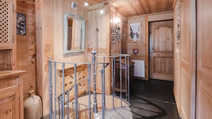 Un intérieur en bois avec un escalier en colimaçon, des murs en bois et un miroir.