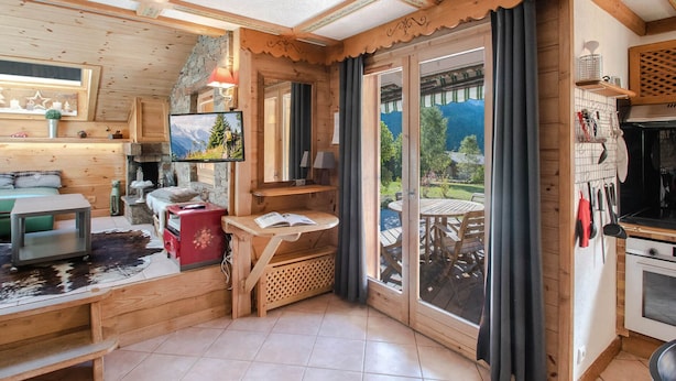 Un intérieur de chalet chaleureux, avec un revêtement en bois, un coin repas et une cuisine.