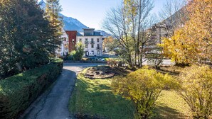Un bâtiment doté d’une cour intérieure, entouré d’arbres et avec une montagne en arrière-plan.