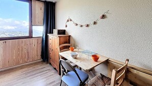 A cozy dining area with a wooden table, chairs, and a view through a window.