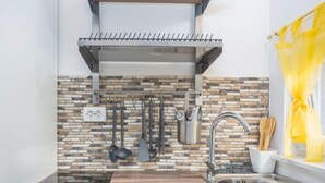 A modern kitchen with a built-in stove, a stainless steel sink, and a backsplash of stone tiles. - Wind Soleil by Interhome (Jablanac)