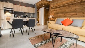 Een moderne woonkamer met een bank, salontafel en eethoek.