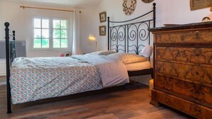A bedroom with a bed, a dresser, a window, and decorative wall art. - Le Glaude by Interhome (Chiddes)
