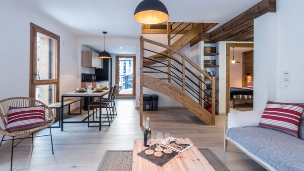 A modern living room with a wooden staircase, a dining area, and a cozy seating area. - 3-star duplex for 6 pers, Chamonix, private parking (Chamonix-Mont-Blanc)