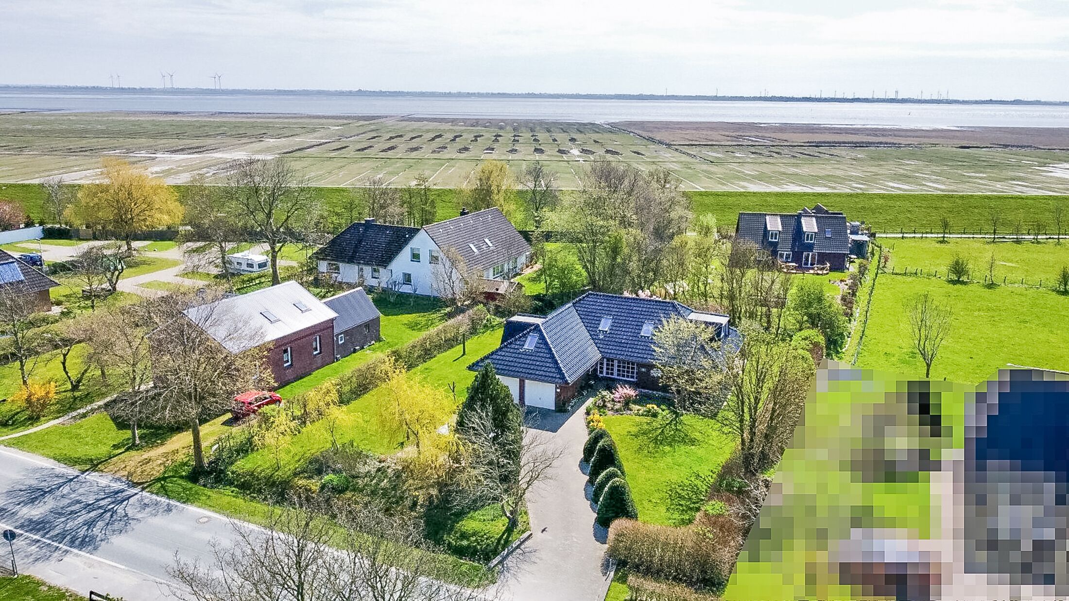 Un quartier résidentiel avec des maisons, une route et un grand champ ouvert.