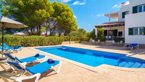 A swimming pool with blue lounge chairs and a covered patio area. - Murada Lisboa by Interhome (Cala Murada)