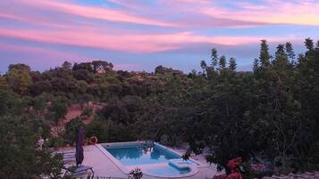 Una piscina con vistas al cielo y árboles circundantes.