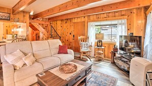 Ein gemütliches Wohnzimmer mit einer Couch, einem Fernseher und Holzwänden.