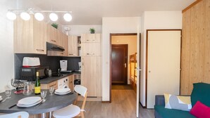 A compact living space with a kitchenette, dining area, and a sofa. - Charming studio with Mont-Blanc view, Wifi and pets allowed (Chamonix-Mont-Blanc)