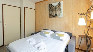 A hotel room with a bed, a painting of a wolf, and a lamp. - Charming studio with Mont-Blanc view, Wifi and pets allowed (Chamonix-Mont-Blanc)