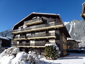 A multi-story building with balconies, a snow-covered landscape, and mountains in the background. - Charming studio with Mont-Blanc view, Wifi and pets allowed (Chamonix-Mont-Blanc)