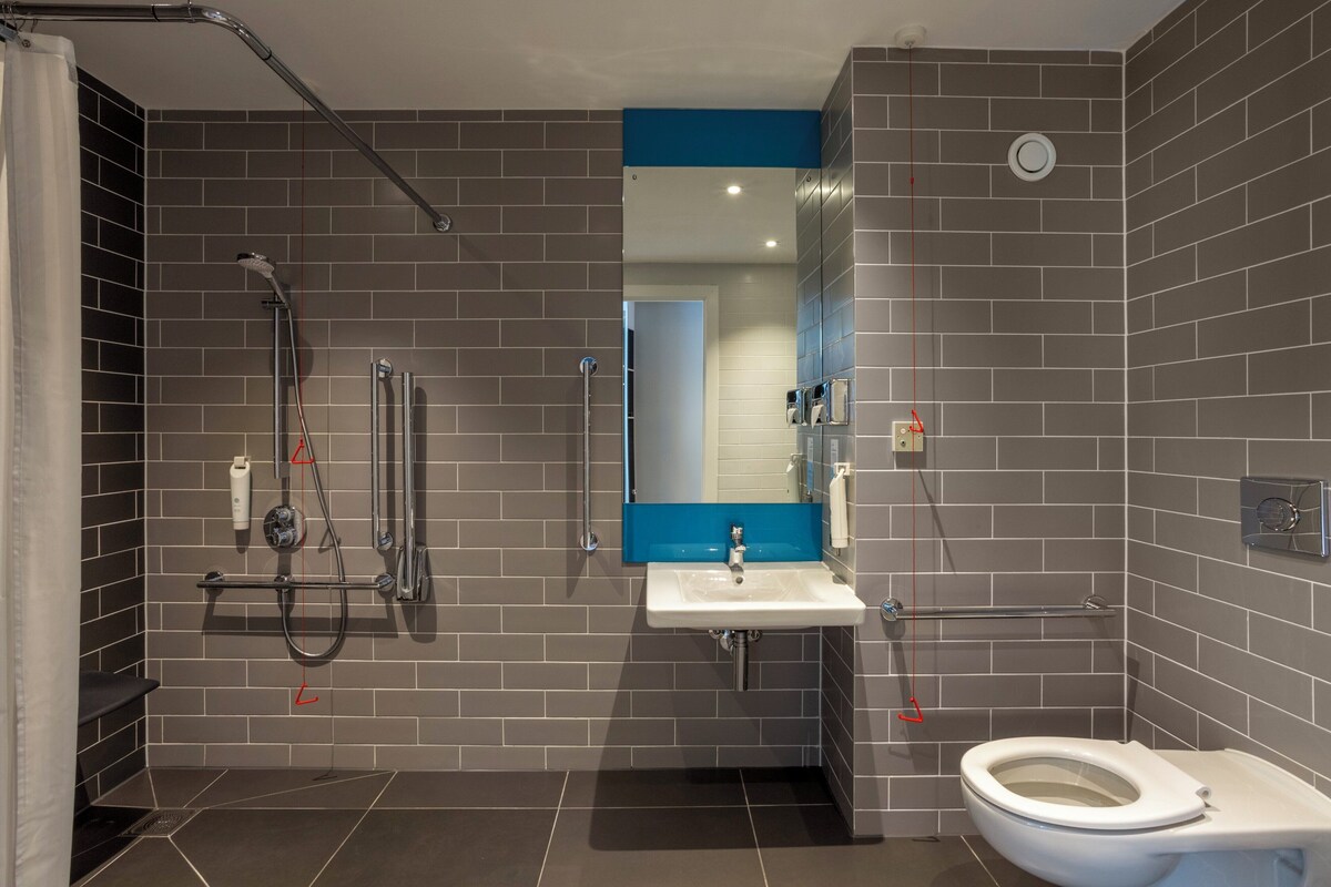 Un bagno moderno con doccia, toilette e lavandino.