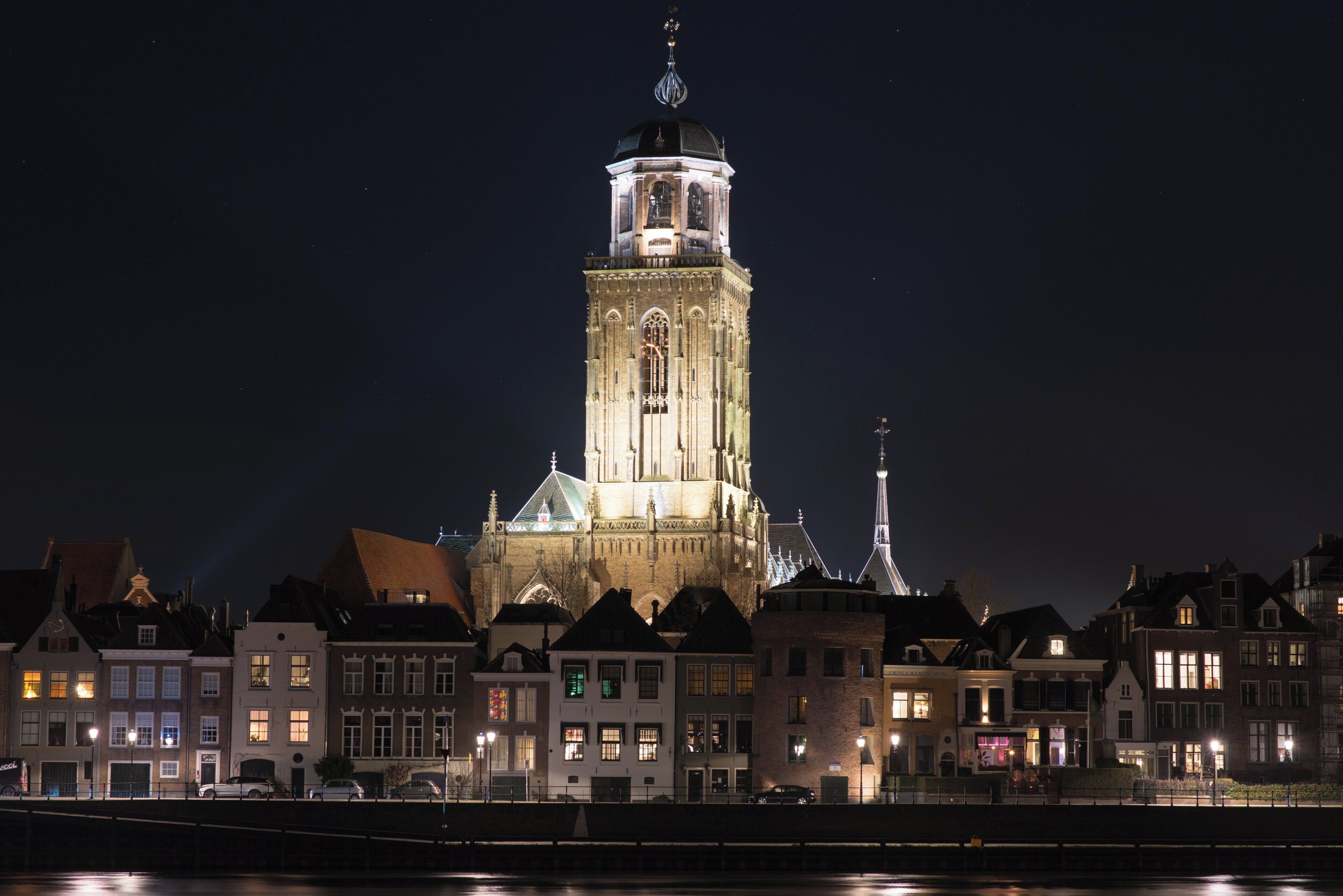 A historic building with a prominent tower and a clock, surrounded by traditional architecture.