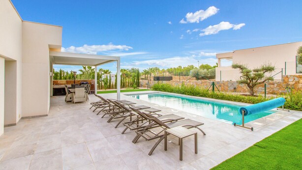 A modern outdoor pool area with a covered seating area and a stone wall. - Amazing home in Dehesa de Campoamor (Dehesa de Campoamor)