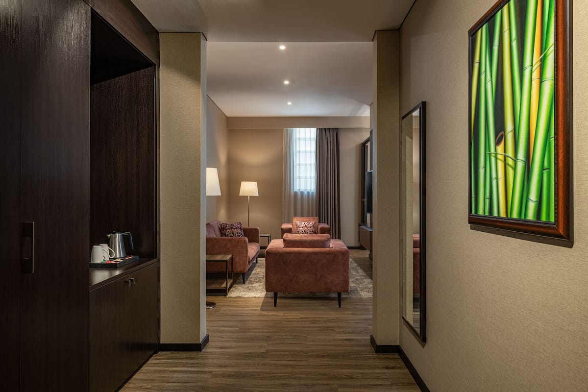 A hotel hallway with a sofa, a coffee table, and a painting on the wall.