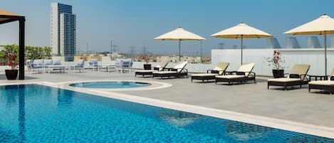 Piscine extérieure, parasols de plage, chaises longues