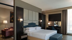 A modern hotel room with a large bed, a desk, a chair, and a sofa. - Four Points by Sheraton Production City, Dubai (Dubai)