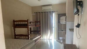 A room with bunk beds, a single bed, a wardrobe, and an air conditioning unit. - Recanto das Tartarugas Aluguel Economico (Arraial do Cabo)