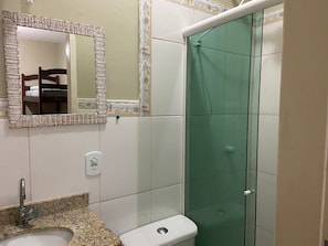 A bathroom with a sink, toilet, and glass shower enclosure.
