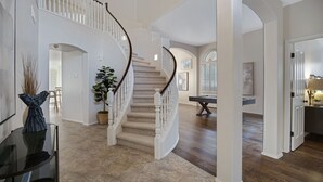 A spacious interior with a curved staircase, a billiards table, and a dining area. - Sweet Escape l Heated Pool l Luxury Living (Scottsdale)