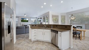 A modern kitchen with white cabinetry, granite countertops, and a built-in dishwasher. - Sweet Escape l Heated Pool l Luxury Living (Scottsdale)
