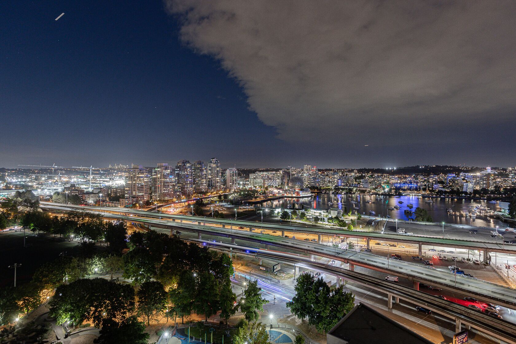 Une vue nocturne d’une ville, avec de nombreuses autoroutes et une rivière.