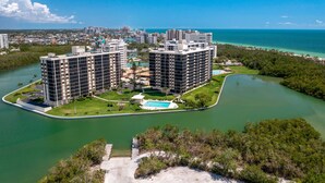 A high-rise hotel with multiple floors, a swimming pool, and a view of the ocean. - 8th Floor Oceanview! Large Balcony ~ Steps to Vanderbilt Beach (Naples)