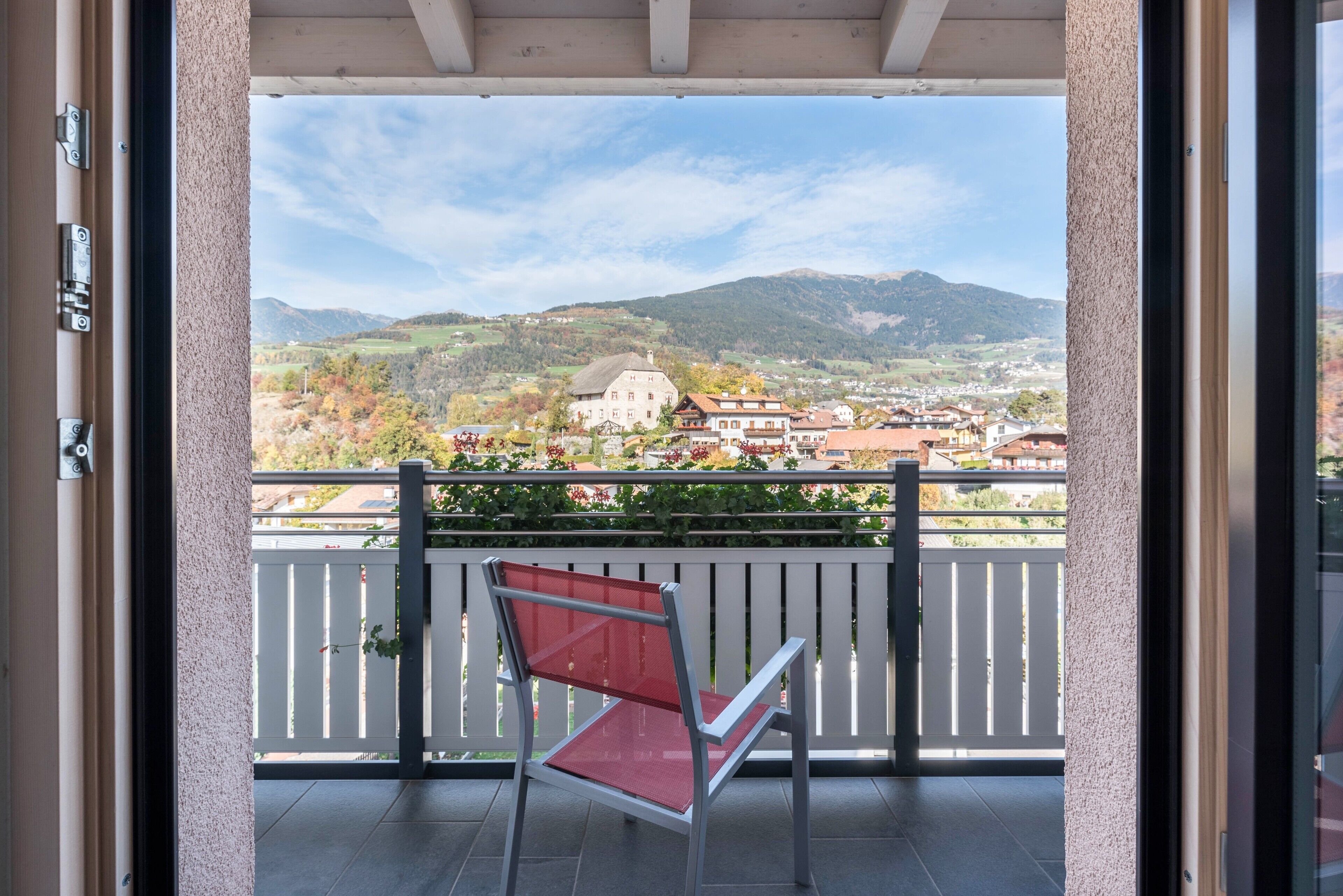 A balcony with a view of a town and mountains.