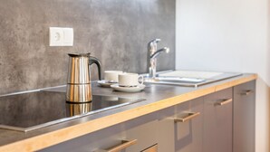 A modern kitchen with a stainless steel kettle, a white cup, and a sink. - Apartments Marialisa Superior 'Apt Tulpe' with Mountain View, Whirlpool & Wi-Fi (Chiusa)