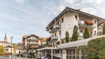 Un hotel a più piani con balconi, un ingresso coperto e un’area parcheggio.