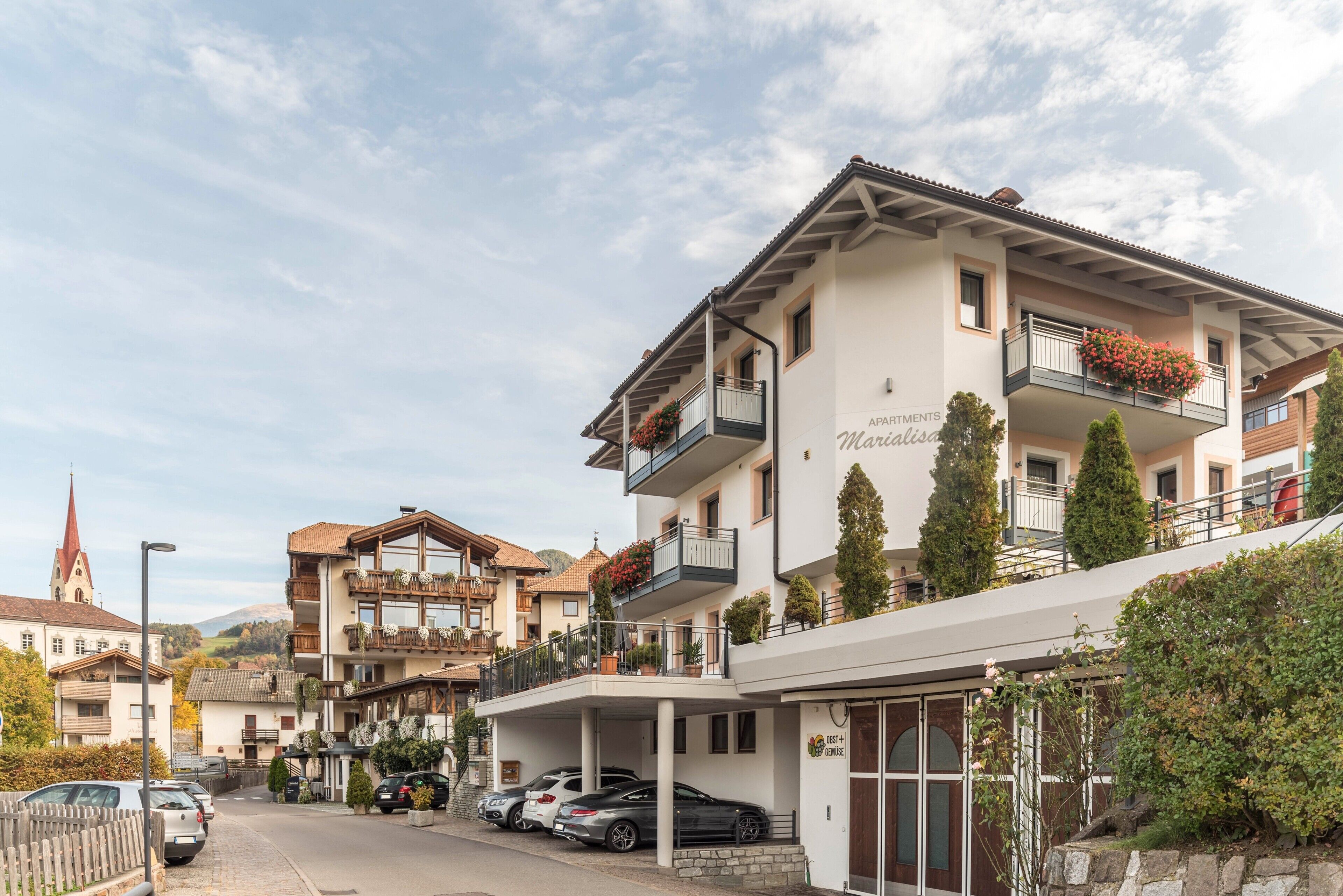 Un hotel a più piani con balconi, un ingresso coperto e un’area parcheggio.