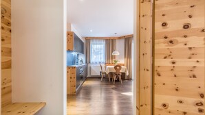 A wooden interior with a kitchen, dining area, and a view of the outdoors. - Apartments Marialisa Superior 'Apt Rose' with Mountain View, Whirlpool & Wi-Fi (Chiusa)