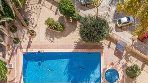 An aerial view of a swimming pool with two dolphins, surrounded by trees and a paved area with benches. - Apartment Moby Dick with Sea View, Shared Pool & Wi-Fi (Benidorm)
