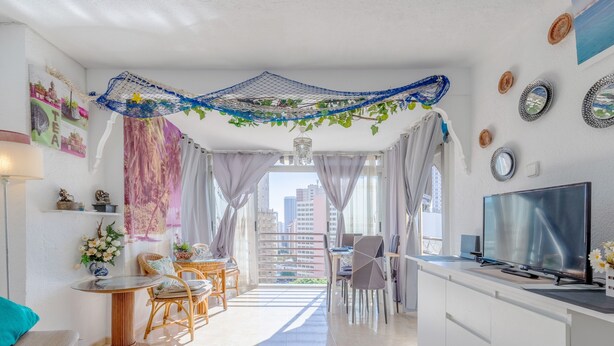 En moderne stue med balkon, spiseplads og et fjernsyn.