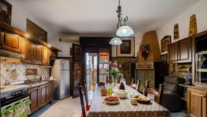 A kitchen with wooden cabinets, a dining table set with dishes, and a hanging light fixture.
