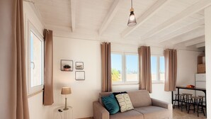 Ein modernes Wohnzimmer mit einer Couch, einer Lampe, gerahmten Bildern und einem Essbereich mit Hockern.