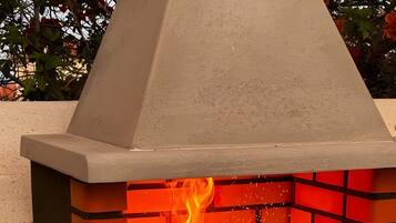 Ein Backofen aus Ziegelsteinen im Freien mit Feuer.