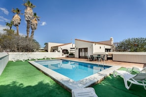 A swimming pool with lounge chairs, a patio area, and a building with a tiled roof. - Holiday Home “3-Bedroom Villa in Golf del Sur” (San Miguel de Abona)