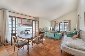 A room with a dining table, chairs, a sofa, a bed, and a view of the outside. - Holiday Home “3-Bedroom Villa in Golf del Sur” (San Miguel de Abona)