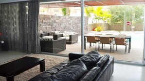 Ein modernes Wohnzimmer mit einer Couch, einem Couchtisch und einem Essbereich mit Tisch und Stühlen.