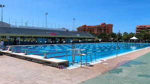 A swimming pool with lanes, a diving board, and a lifeguard chair. - 2-Bedroom Apartment on Los Cristianos Beach with Promenade Views (Los Cristianos)
