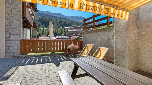 An outdoor seating area with a wooden bench, a picnic table, and a wooden fence. - Apartment 'Vittoria Bilo' with Mountain View, Terraces & Wi-Fi (Valfurva)