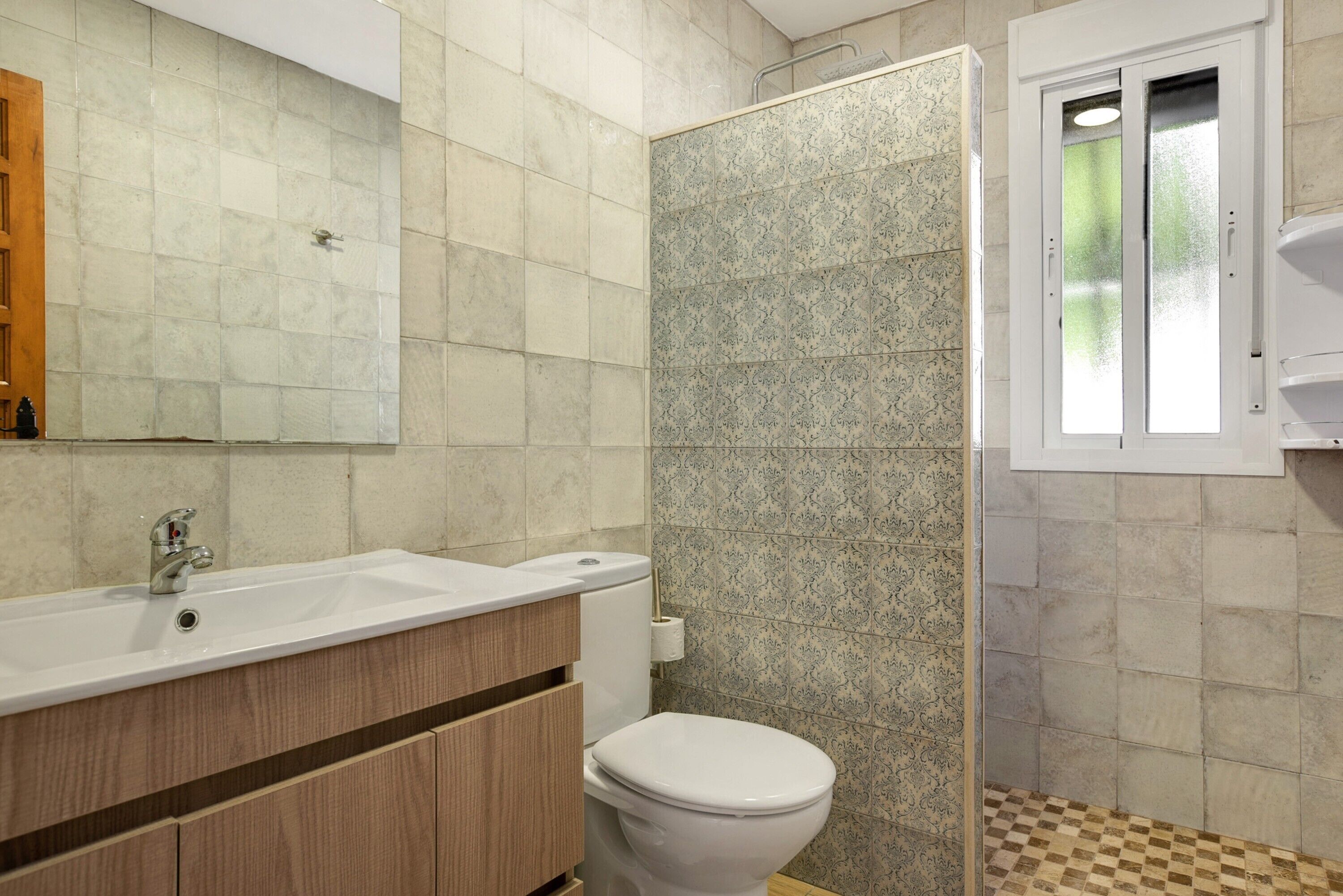 Une salle de bain comprenant un lavabo, des toilettes et un espace douche.