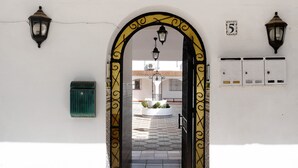 An arched doorway with decorative metalwork, a green mailbox, and a wall-mounted electrical panel. - Pet-Friendly 'Apartment en la Playa 2' with Terrace & Wi-Fi (Conil de la Frontera)