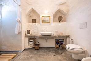 Une salle de bain avec un lavabo blanc, un miroir, des toilettes et un rideau de douche.