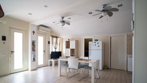 A spacious room with a dining table, chairs, ceiling fans, and a refrigerator. - Holiday Home "Giugiò" with Mountain View, Terrace, and Air Conditioning (Giardini Naxos)