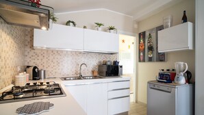 A modern kitchen with a gas stove, microwave, sink, and dishwasher. - Holiday Home "Giugiò" with Mountain View, Terrace, and Air Conditioning (Giardini Naxos)