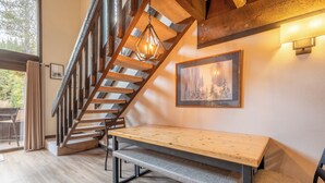 A wooden staircase with a bench at the bottom, a framed picture on the wall, and a hanging light fixture. - Ski in/Walk out Center Village condo, Excellent location, Mountain View (copper mountain)