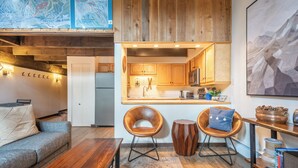 A cozy living room with a wooden coffee table, two leather chairs, a sofa, and a rug. - Ski in/Walk out Center Village condo, Excellent location, Mountain View (copper mountain)